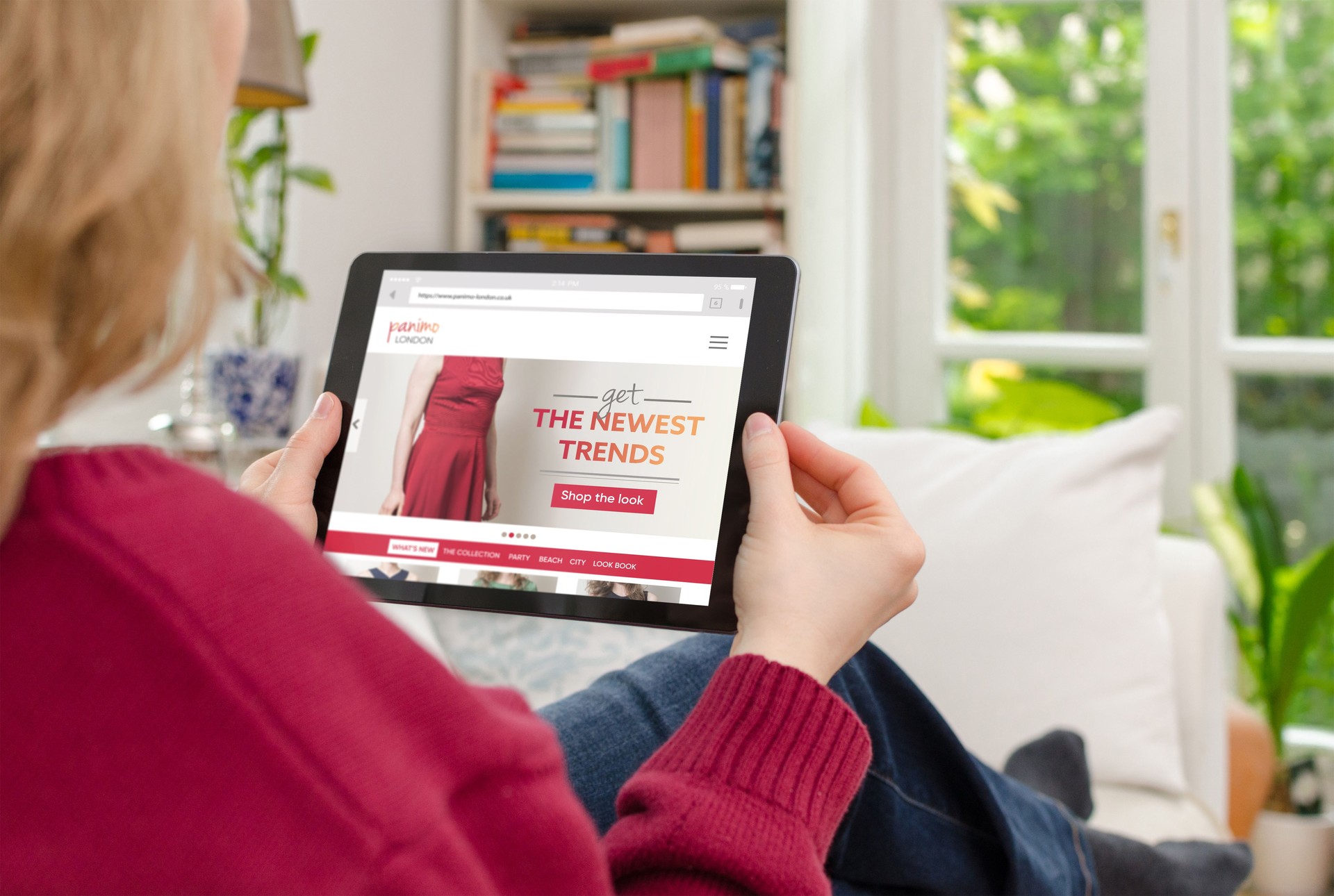 Blond woman is looking at digital tablet computer to shop online on the internet