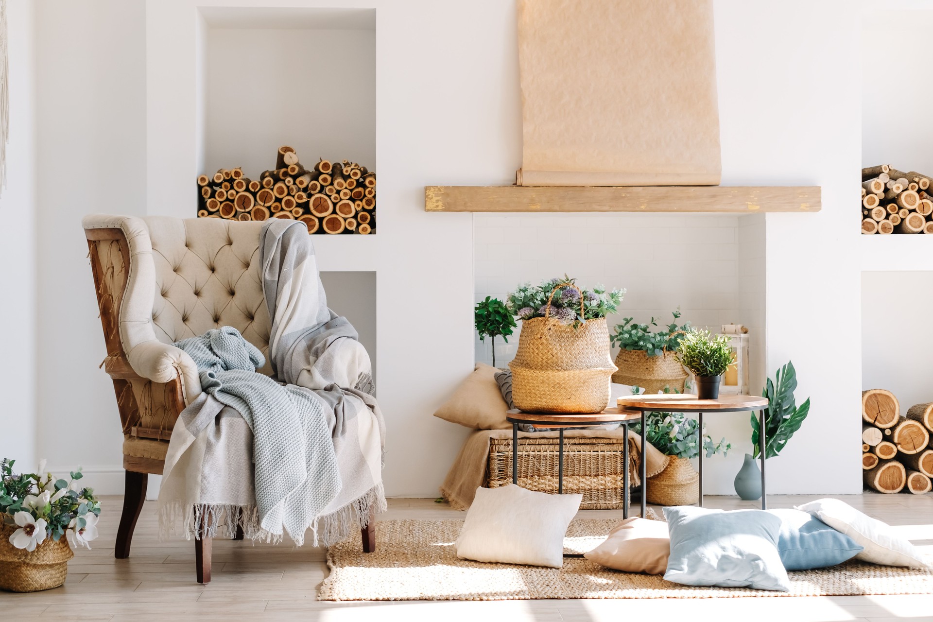 Interior of bright living room in scandinavian style with large armchair, offee table and plants.